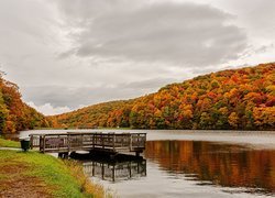 Pomost na jeziorze otoczonym jesiennymi drzewami