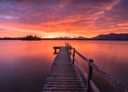 Pomost na jeziorze pod kolorowym niebem zachodzącego słońca