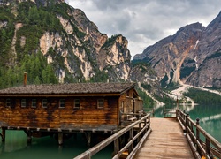 Pomost z drewnianą chatą nad górskim jeziorem Pragser Wildsee we Włoszech