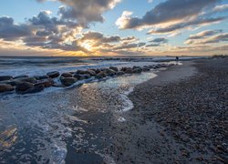 Poranek nad kamienistą morską plażą