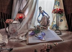 Porcelanowa figurka obok książki i dzbanka