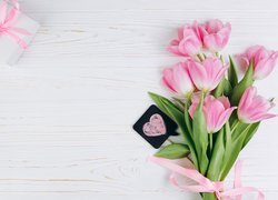 Prezent obok różowych tulipanów