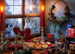 Prezenty świąteczne obok ciasteczek i wina przy oknie
