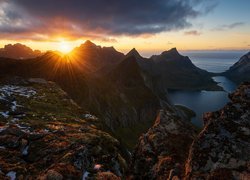Promienie słońca i chmury nad górami na norweskich Lofotach