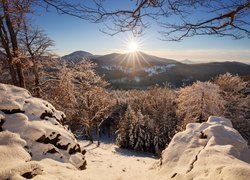 Promienie słońca nad górami zimową porą