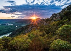 Promienie zachodzącego słońca nad rzeką Dunaj i górami w Austrii