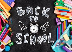 Przybory szkolne i napis Back to School na czarnym tle