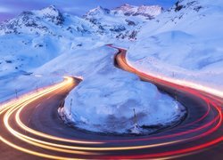 Refleksy świetlne na krętej drodze w zimowych górach