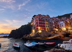 Włochy, Cinque Terre, Miejscowość, Riomaggiore, Domy, Morze, Skały, Zatoka, Łódki, Zachód słońca