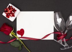 Róża i kieliszki przy białej kartce
