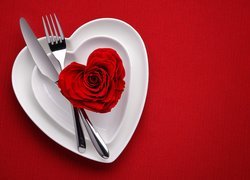 Róża i sztućce na talerzach w kształcie serca