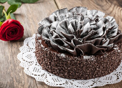 Róża obok czekoladowego tortu