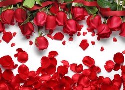 Róże ułożone na blacie obok małych czerwonych serduszek i płatków