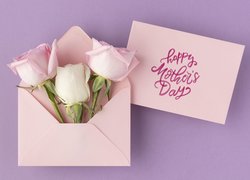 Róże w kopercie obok kartki z życzeniami na Dzień Matki