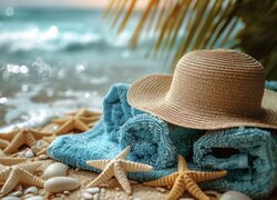 Rozgwiazdy i niebieski ręcznik z kapeluszem na plaży