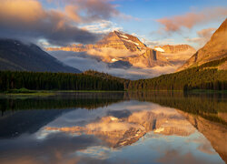 Rozświetlone góry i las nad jeziorem Swiftcurrent Lake w Parku Narodowym Glacier