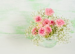 Różowe róże i gipsówki w szklanym wazoniku