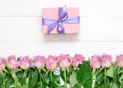 Różowe róże i prezent w różowym opakowaniu