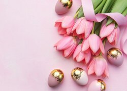 Różowe tulipany i pozłacane jajka na jasnym tle