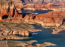 Rozświetlone czerwone skały nad jeziorem Powell Lake w Utah