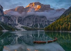 Rozświetlone Dolomity i łódki na jeziorze Pragser Wildsee