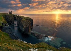 Ruiny zamku Sinclair na wybrzeżu Szkocji o zachodzie słońca
