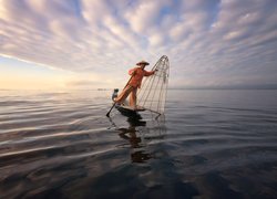 Rybak z siecią na morzu