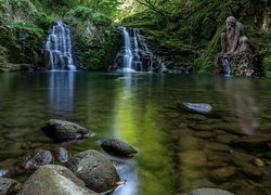 Rzeźba obok wodospadów na skale nad jeziorem