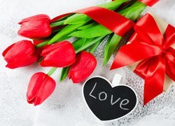 Serce z napisem love przy prezencie i tulipanach