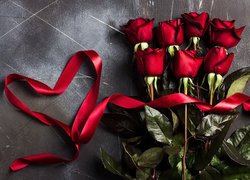 Serce ze wstążki obok czerwonych róż
