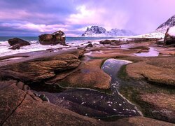 Skaliste wybrzeże i ośnieżone góry w Norwegii