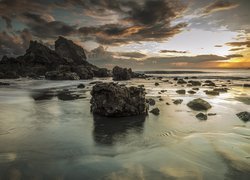 Skały i kamienie w morzu o zachodzie słońca