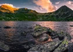 Skały i rozświetlone góry nad jeziorem