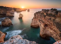 Skały na wybrzeżu Algarve w blasku wschodzącego słońca