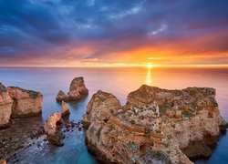 Portugalia, Region Algarve, Cypel Ponta da Piedade, Morze, Skały, Chmury, Wschód słońca