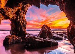 Skały w jaskini z widokiem na kolorowy zachód słońca