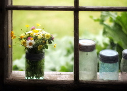 Słoik z bukietem polnych kwiatów na parapecie okna