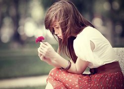 Smutna dziewczyna z kwiatkiem w dłoniach