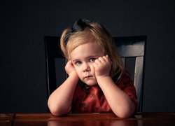 Smutna dziewczynka przy stole