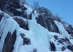 Śnieg i sople na skalnym wodospadzie