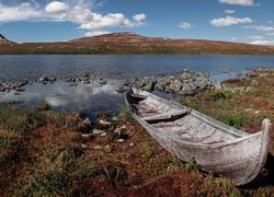 Stara łódź na brzegu górskiego jeziora