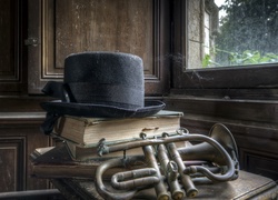 Stare książki z trąbką i kapeluszem w kompozycji