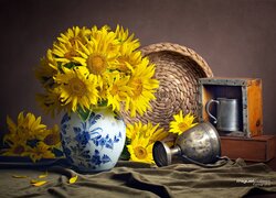 Stare naczynia obok wazonu z bukietem słoneczników