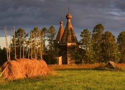 Stogi siana na polu niedaleko kościoła