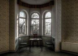 Stół i krzesła ustawione przy oknie w pokoju we wnęce