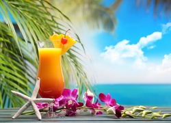 Storczyk przy drinku na tle morza i palm