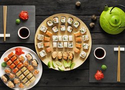 Sushi na talerzykach obok czajnika