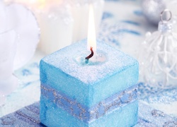 Świąteczna dekoracja z niebieską paląca się świecą