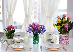 Świąteczny stół z nakryciami i bukietami kwiatów