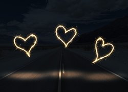 Świecące serca na drodze w ciemności